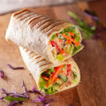 halbes Wrap mit Salat, Sour Cream, veganem Gyros, Kraut, Tomate und Gurke
