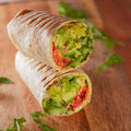 halbes Wrap mit  Avocado, Feta, Spinat, gegrilltem Kürbis und Süßkartoffeln.