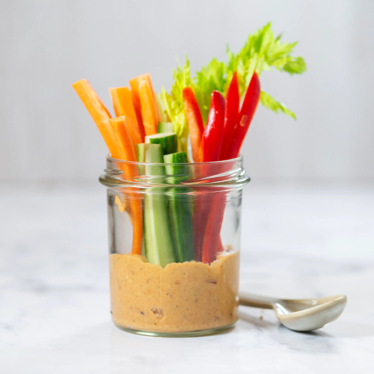 Salädchen - frische Paprika, Gurken, Sellerie und Karottenstückchen auf würzigem Hummus