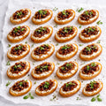 Bruschetta mit Süße karamellisierte Zwiebeln, dazu cremiger Ziegenkäse und frischen Kräutern. 20 Portionen
