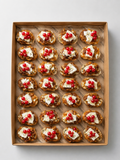 Bruschetta mit cremiger Brie mit Preiselbeersoße und gerösteten Haselnüssen. 20 Portionen